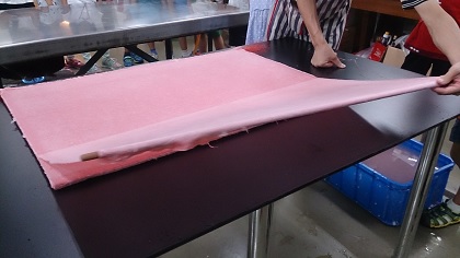 大型手工紙抄製過程之一，烘紙前的步驟，壓紙後揭紙準備烘乾。
