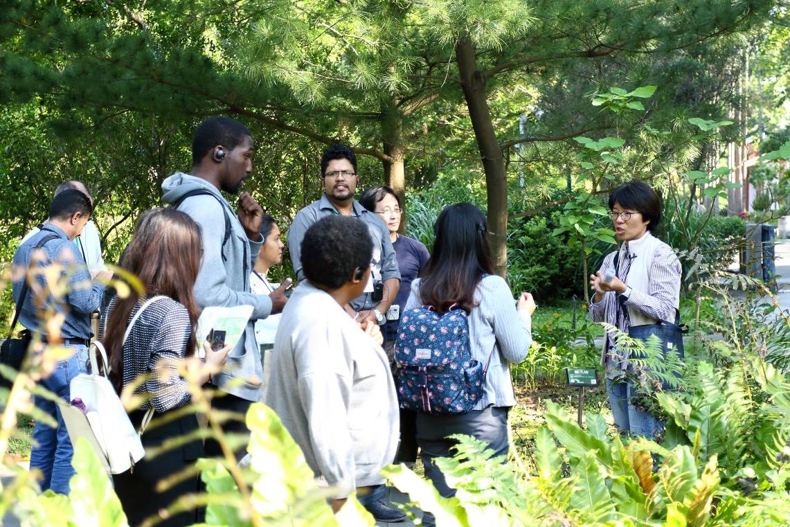在植物園展示區內，向訪賓介紹臺灣稀有植物的收集情形，以及這些稀有植物在園內的生長狀況。